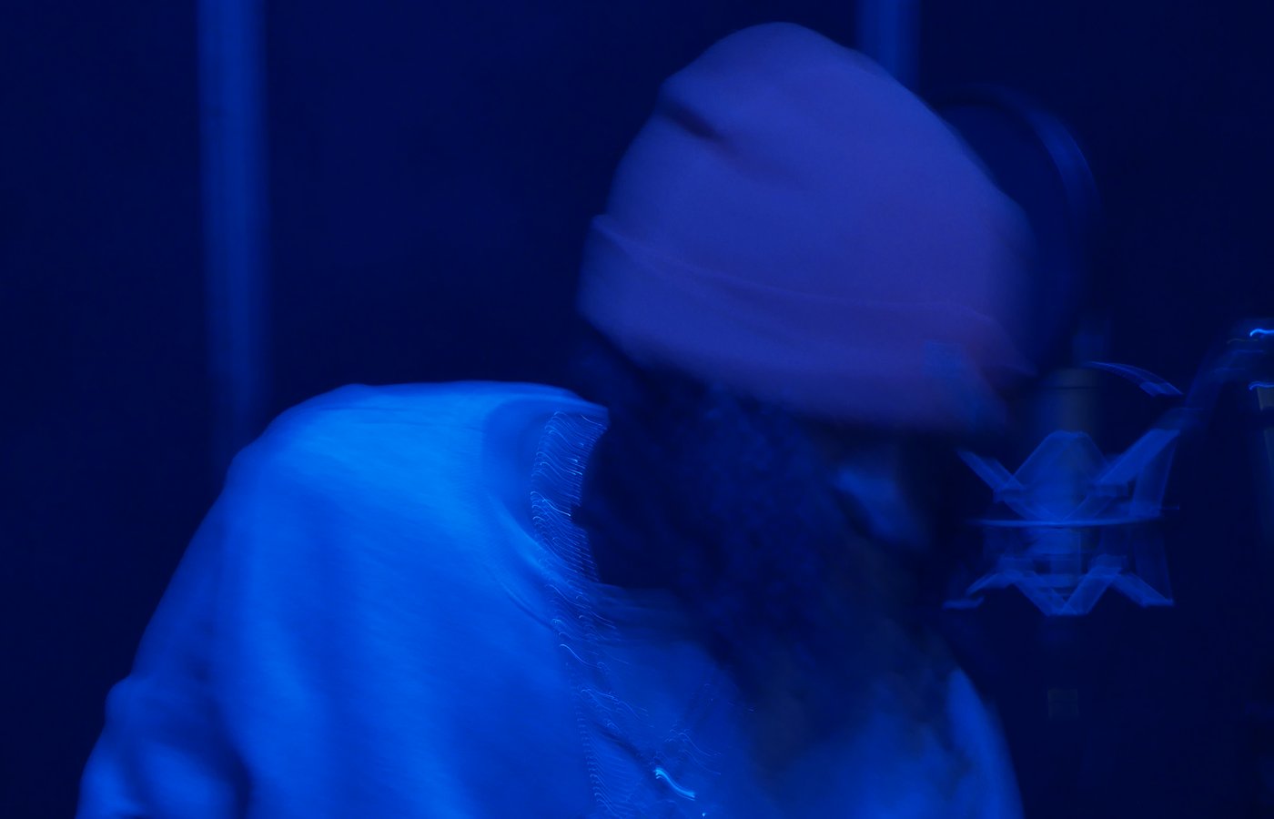 King Zeus on the mic under blue studio light